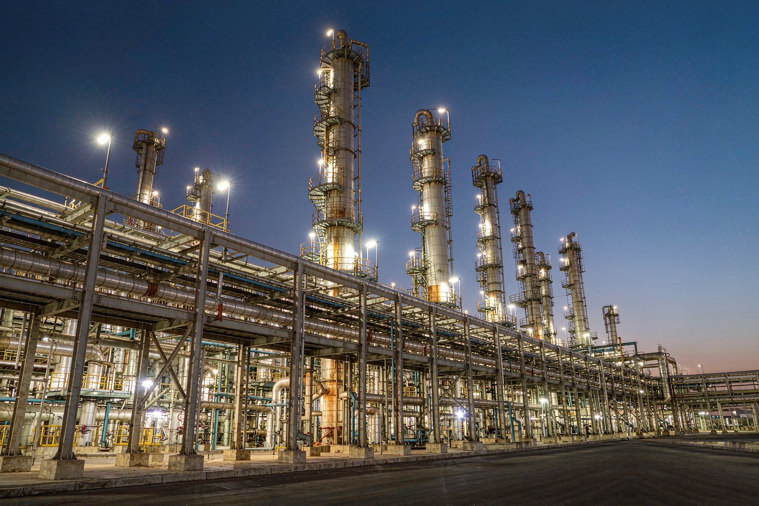 Pipe racks and process units at night in Malaysia with explosion-proof linear luminaires installed along the structure